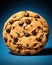 Single chocolate chip cookie isolated on blue background