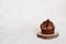 Single chocolate expresso cupcake on wooden plate on white background. Horizontal photo.