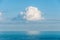 Single cloud suspended in the sky over the ocean.