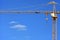 Single construction crane on the blue sky background