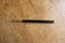 Single crochet hook with black plastic handle on wood