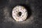 Single delicious donut on dark background with colorful sprinkle concept  top view