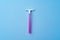 Single disposable razor for women on blue background