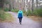 Single elderly woman walking alone in forest for good mental and physical health