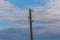 Single electricity pole with wires on the blue sky background.