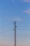 Single electricity pole with wires on the blue sky background.