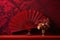 a single elegant hand fan open against a rich, velvety red backdrop