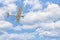 Single engine ultralight plane flying in the cloudy blue sky