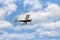 Single engine ultralight plane flying in the cloudy blue sky