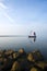 Single fisher boat on silent water in morning mist