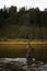 Single fisherman on a calm river is autumn fishing