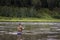 Single fisherman on a calm river is autumn fishing