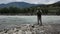 Single fisherman on a stormy river is fishing on a sunny summer day