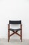 Single folding wooden director chair on white cement wall background