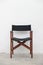 Single folding wooden director chair on white cement wall background