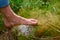 A single foot steps barefoot on a giant puffball, mushroom, a cloud of dust explodes into the environment