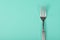 Single fork on a turquoise blue background with space for copy