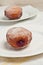 Single frehley baked raspberry filled donut on white plate