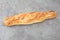 Single french baguette in grey background