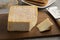 Single French Le Carre du Pere Antoine cheese and a piece on a cutting board