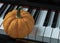 Single fresh orange pumpkin stands on the Piano eyboard