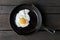 Single fried egg in cast iron frying pan sprinkled with ground b