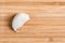 A single garlic clove on a wooden kitchen table