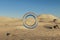 single glas ring hovering in the air in large empty desert environment abstract surreal concept 3D Illustration