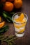 Single Glass with fresh juicy ripe Mandarins Tangerines, ice. Copy space and Closeup on dark background. Top view