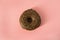 Single glazed chocolate donut on peach background - minimalism, copy space