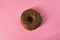 Single glazed chocolate donut on pink background - minimalism, copy space