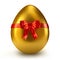 Single golden egg with red ribbon and bow