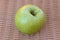 Single Granny Smith apple isolated on brown background