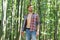 Single handsome guy with sexy bare torso in open shirt casual style stand in woods on sunny summer day natural landscape