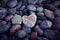 Single heart on black pebble stones