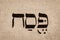 Single hebrew word Pesach on page of old Torah book. English translation is Passover. Jewish holiday