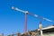 Single high-rise construction crane on the blue sky background.