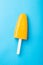 Single homemade orange popsicle on a blue background. Top view
