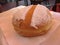 Single Krapfen italian doughnut covered with icing sugar on napkin