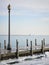 Single lamp light post on icy pier in winter