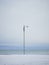 Single lamppost on snowy beach