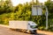 Single lorry truck on uk motorway road under information display at sunset