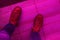 Single male feet in leather boots shoegaze in artificial club light top view