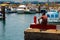 A single male fishing from the concrete jetty in the crowded marina at Los Cristianos on the Island of Teneriffe in the