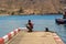 A single male fishing from the concrete jetty in the crowded marina at Los Cristianos on the Island of Teneriffe in the