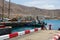 A single male fishing from the concrete jetty in the crowded marina at Los Cristianos on the Island of Teneriffe in the