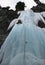 Single male ice climber on a steep waterfall in the Swiss Alps