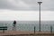 Single man back view on fence front of atlantic ocean in city Biarritz Basque Country France