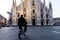 Single man on bicycle standing alone in front of Milan`s Cathedr