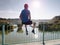 Single Man in sport clothing sit on bridge handrail